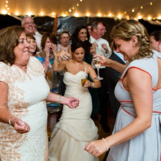 Bride and guests dancing joyfully under string lights at Newagen Seaside Inn wedding in Maine.