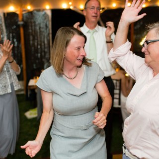 Two women dancing joyfully at Newagen Seaside Inn wedding in Southport, Maine.