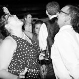 Joyful guests laughing together at a black and white wedding celebration on Block Island.