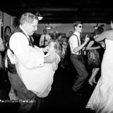 Groom dancing with child as bride and guests celebrate at Spring House Hotel wedding.