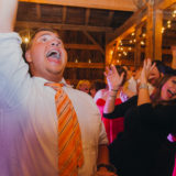 Guests dancing and celebrating at a rustic barn wedding in Lloyd Neck, New York.