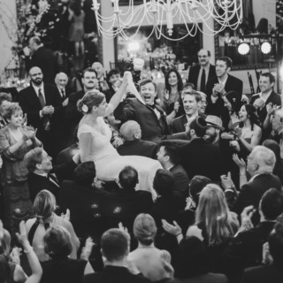Bride and groom lifted during Horah dance at Alden Castle wedding in Brookline, Massachusetts.