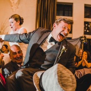 Bride and groom lifted during joyful Jewish Hora dance at Alden Castle wedding in Brookline.