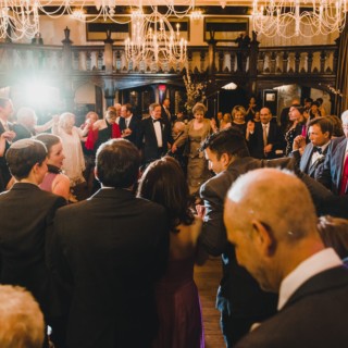 Elegant wedding reception at Alden Castle in Brookline with dancing guests and warm chandelier lighting.
