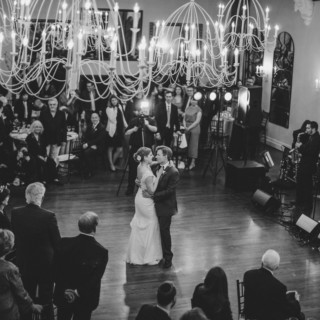 Bride and groom share a romantic first dance under chandeliers at Alden Castle wedding.