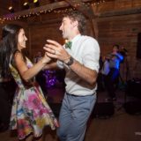 Couple dancing joyfully in rustic barn wedding with live band in Bristol, Vermont.