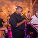 Live band performing at cozy Vermont wedding with bass, trombone, and saxophone players.