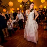 Bride dancing on wooden floor surrounded by cheering guests at Bar Harbor wedding reception.