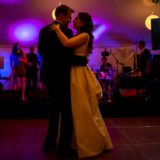 Couple shares a romantic first dance under colorful lights at a Bar Harbor wedding.
