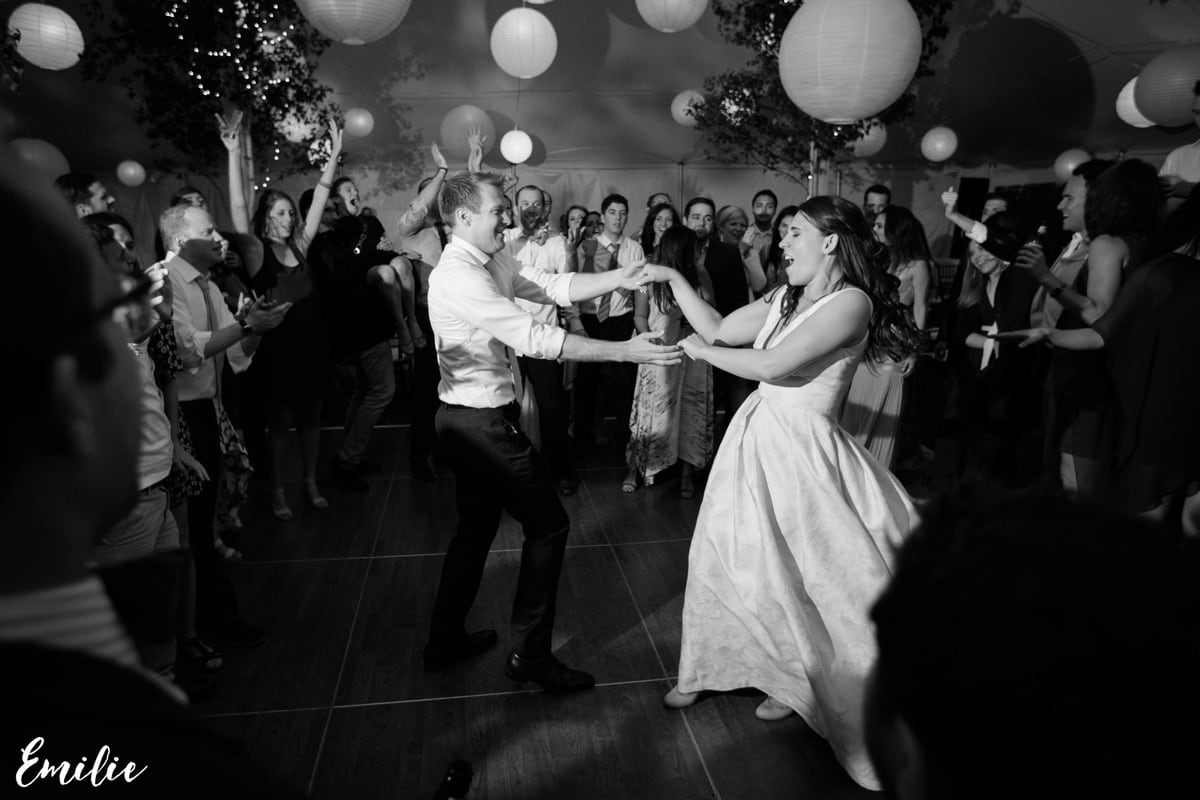Bride and groom dancing joyfully surrounded by cheering guests at a Bar Harbor wedding.