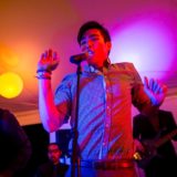 Energetic live band performing under colorful lights at a vibrant Bar Harbor wedding celebration.