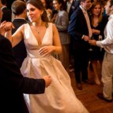 Bride and groom dancing at elegant Bar Harbor wedding reception surrounded by joyful guests.