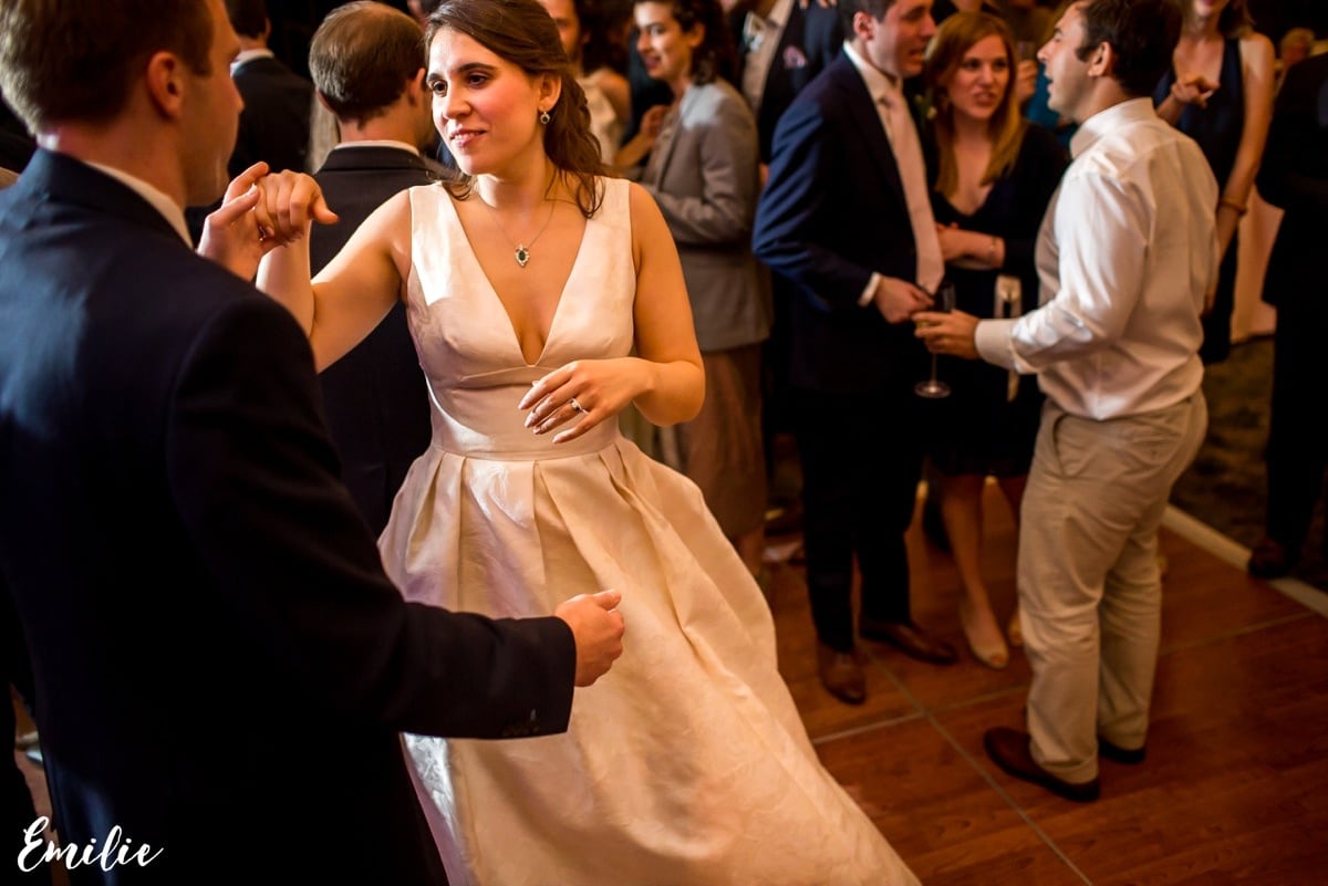 Bride and groom dancing at elegant Bar Harbor wedding reception surrounded by joyful guests.