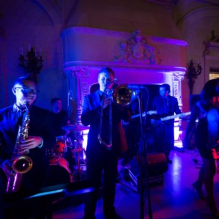Elegant jazz band performing live at a Newport wedding under vibrant blue and red lights.