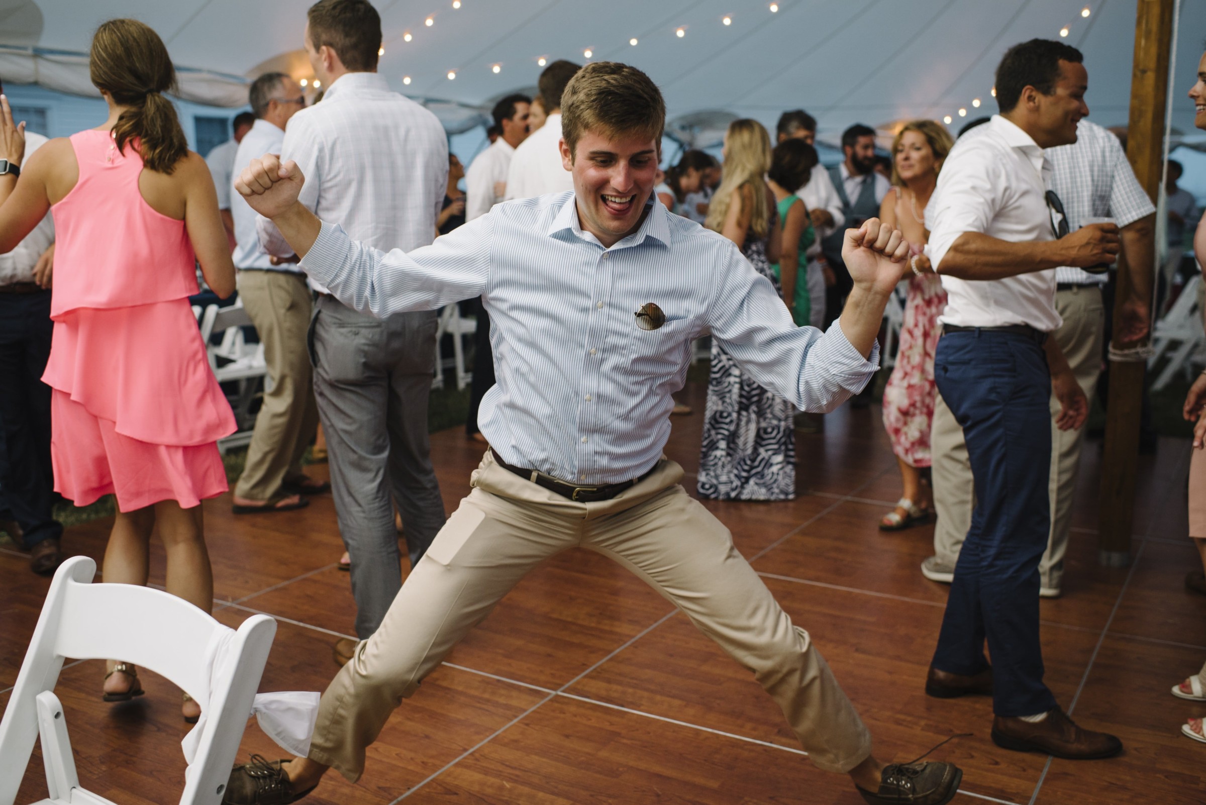 Guest joyfully dancing under string lights at Cuttyhunk Island wedding reception.