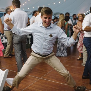 Guest joyfully dancing under string lights at Cuttyhunk Island wedding reception.