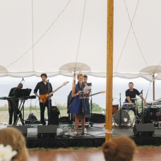 Live band performing under white tent at seaside wedding on Cuttyhunk Island, Massachusetts.