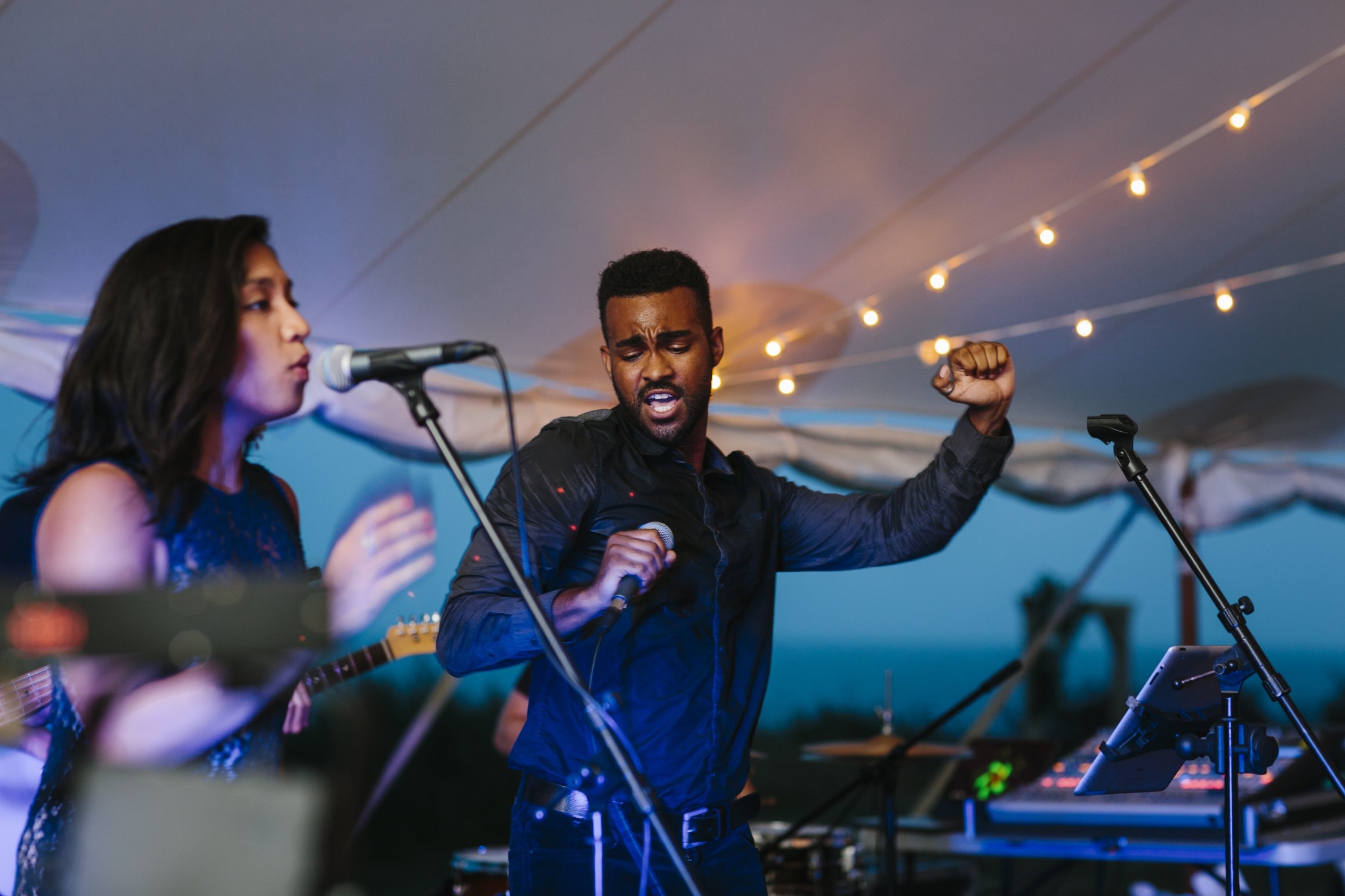 Singers perform a passionate live wedding duet under string lights on Cuttyhunk Island.