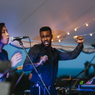 Singers perform a passionate live wedding duet under string lights on Cuttyhunk Island.