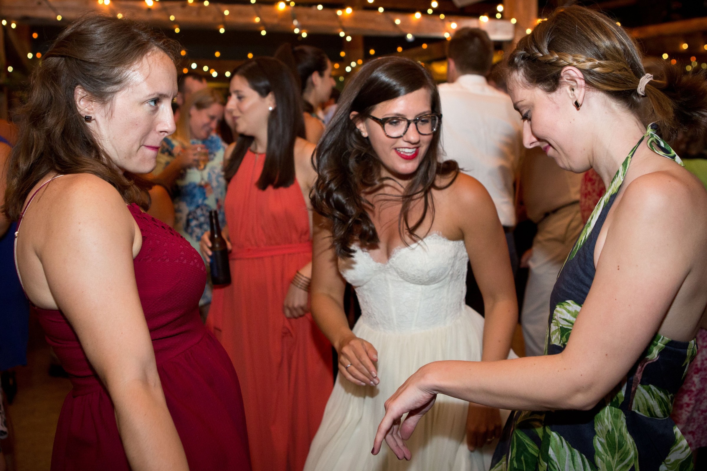 Bride dancing and laughing with friends at Stone Mountain Arts Center wedding in Maine.