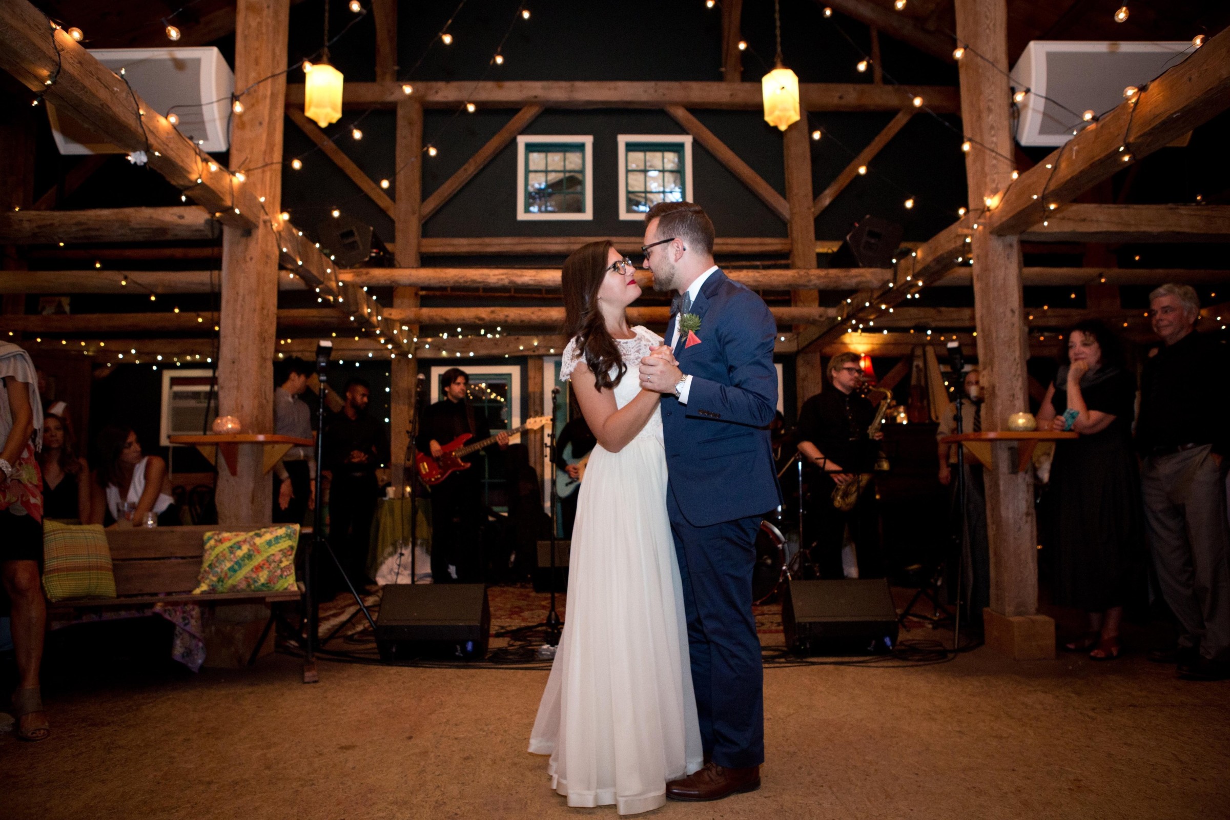Bride and groom first dance at rustic barn wedding with string lights in Brownfield, Maine.