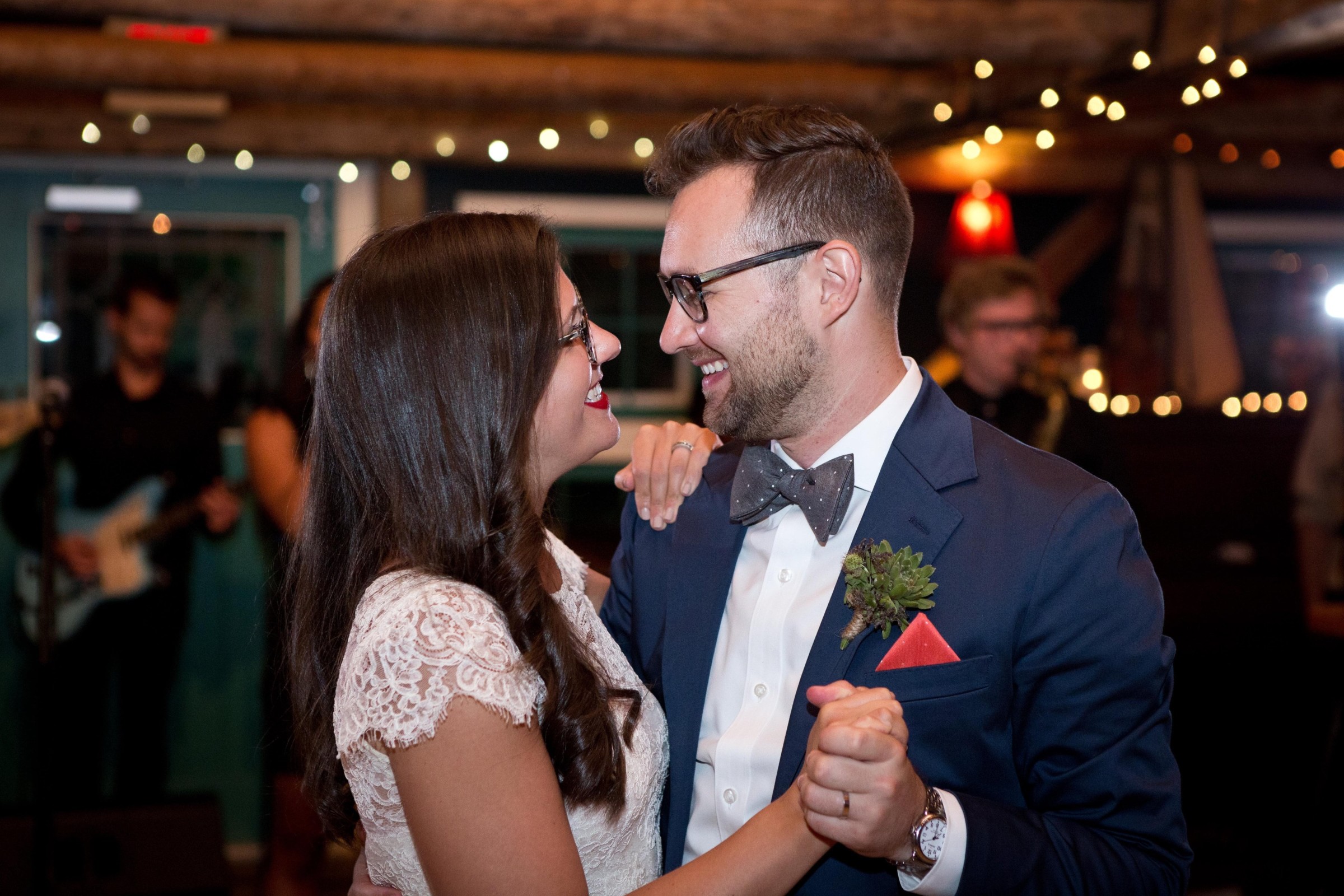 Couple sharing a romantic first dance under warm string lights at Stone Mountain Arts Center.