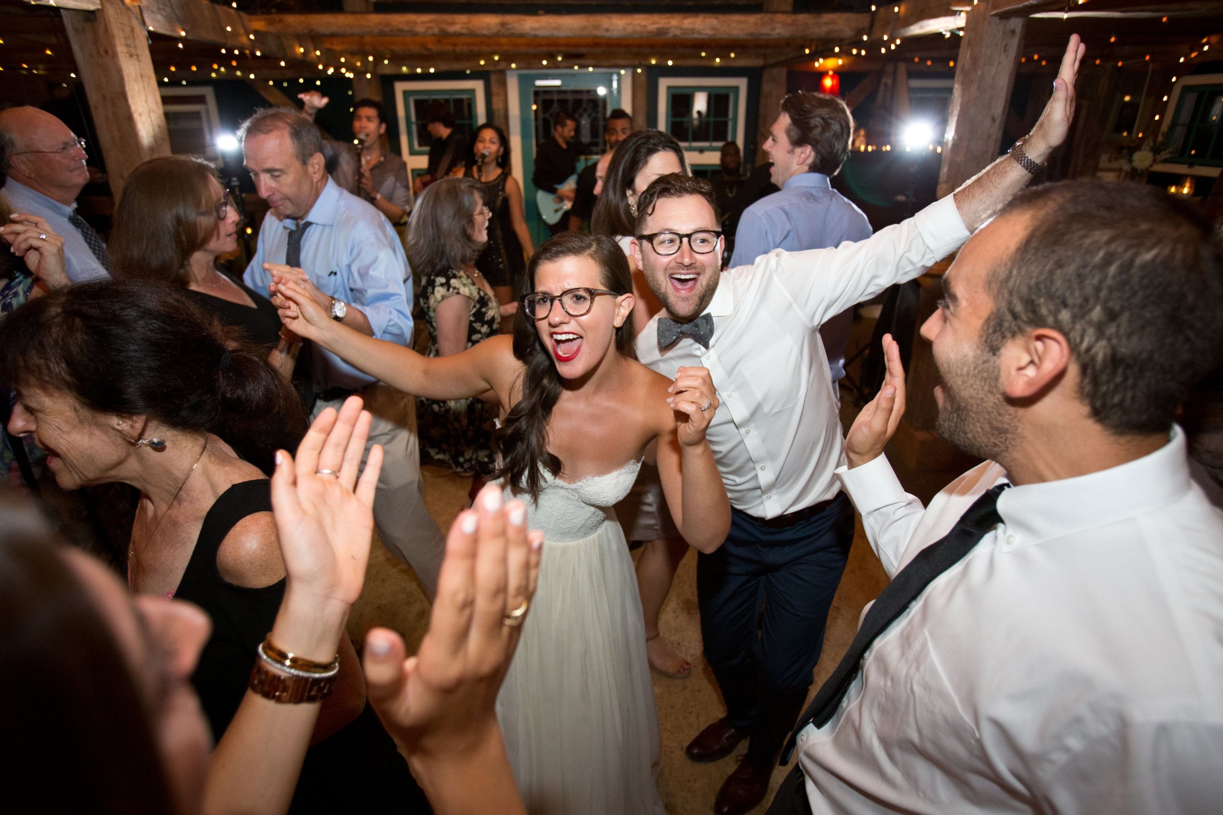 Bride and groom dancing joyfully with guests at rustic Stone Mountain Arts Center wedding.