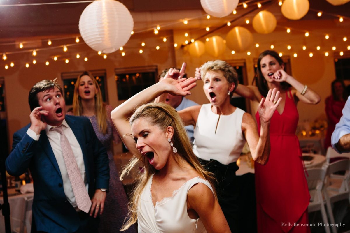 Bride and guests dancing joyfully under warm string lights at Duxbury Bay Maritime School wedding.