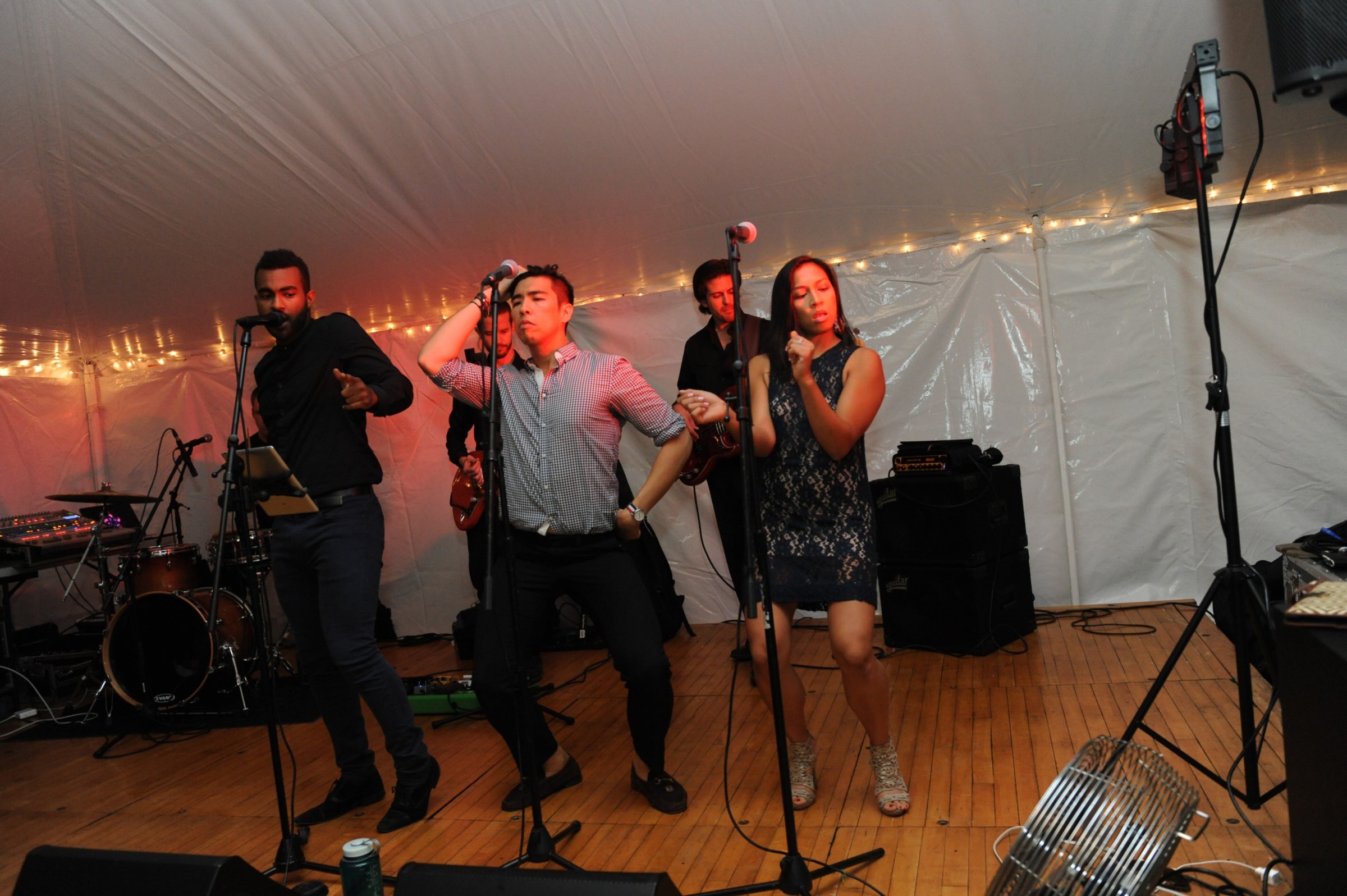 Live band performing under white tent at elegant Boston wedding celebration.