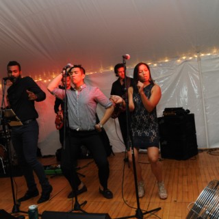 Live band performing under white tent at elegant Boston wedding celebration.