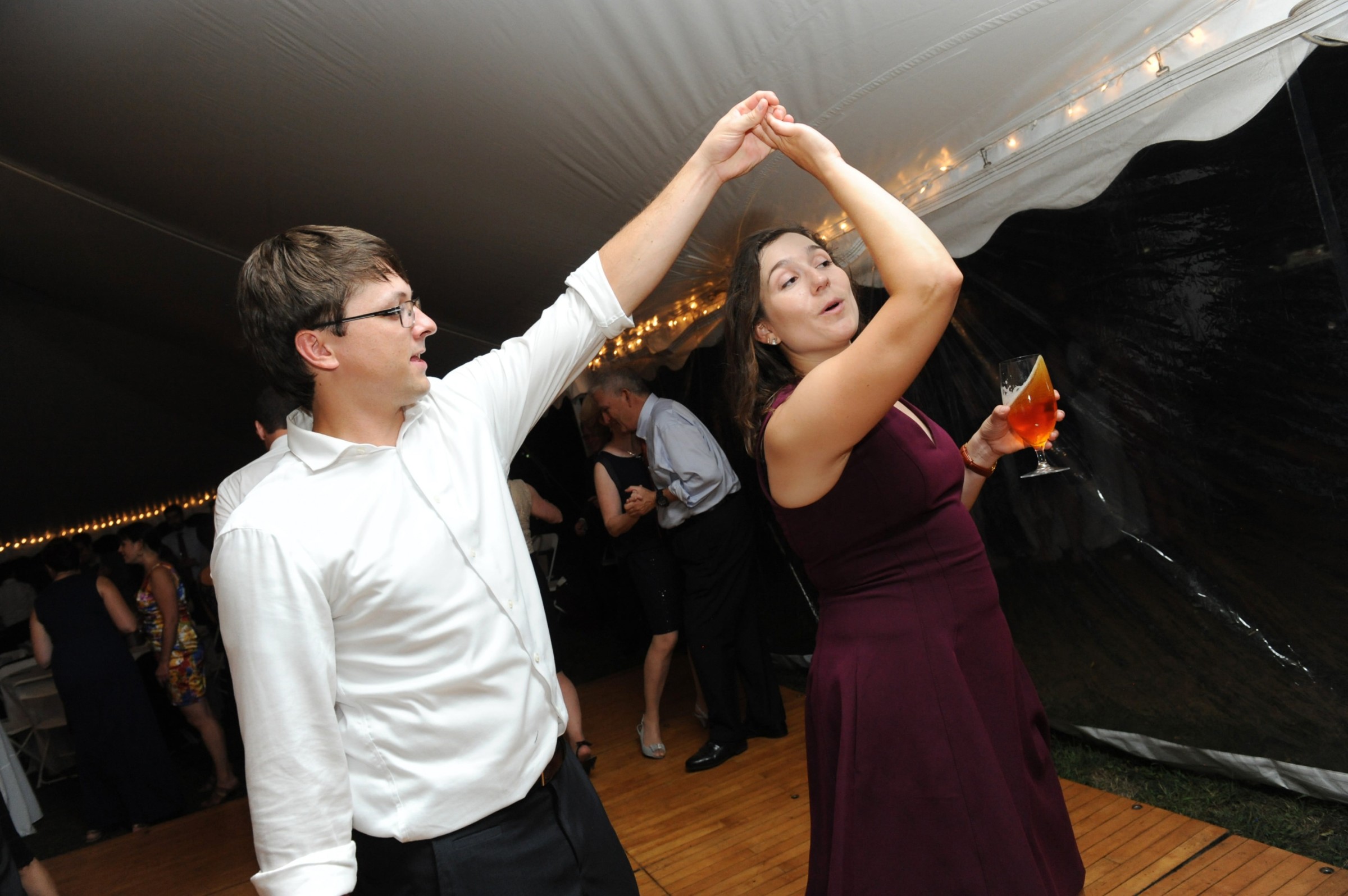 Couple dancing joyfully under wedding tent at Loring Greenough House in Boston.