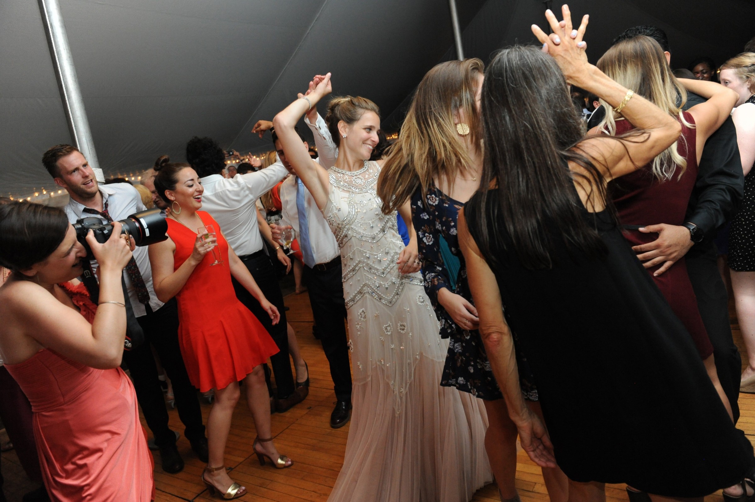 Bride dancing joyfully with guests at lively Loring Greenough House wedding reception in Boston.