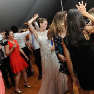 Bride dancing joyfully with guests at lively Loring Greenough House wedding reception in Boston.