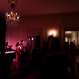 Live band performing at elegant Glen Manor House wedding reception under warm pink lighting.