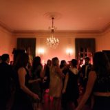 Guests dancing under chandelier at elegant Glen Manor House wedding reception in Portsmouth, Rhode Island.