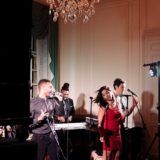 Elegant live wedding band performing at Glen Manor House with energetic singer in red dress.