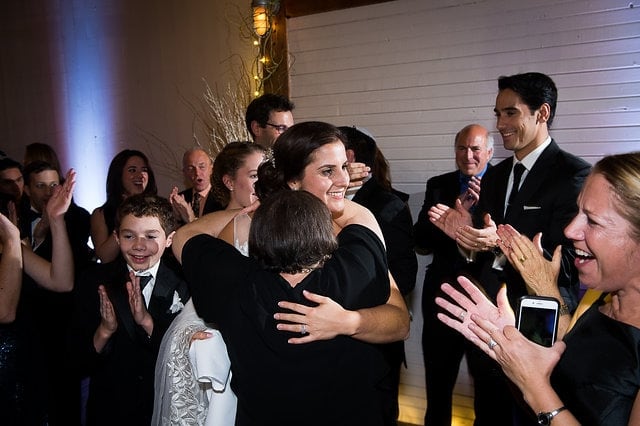 Bride hugging loved one amid joyful celebration at Gedney Farm wedding in New Marlborough, Massachusetts.