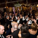Bride and groom celebrating joyful barn wedding at Gedney Farm under warm glowing lights.