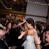 Bride dancing joyfully amid cheering guests at rustic Gedney Farm wedding in New Marlborough, Massachusetts.