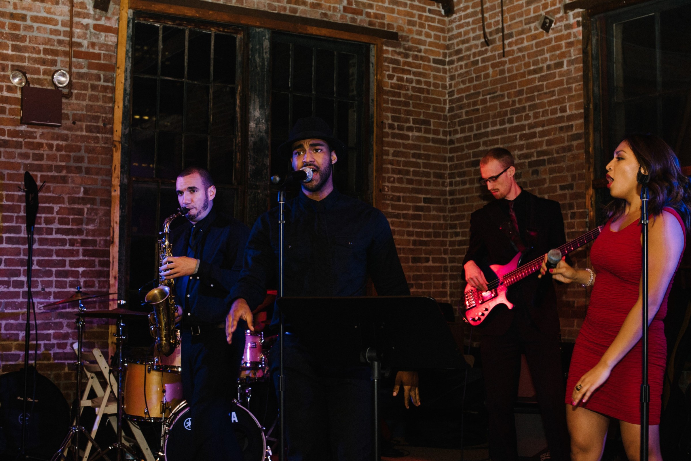 Live jazz band performing in a cozy urban loft with warm lighting and rustic brick walls.