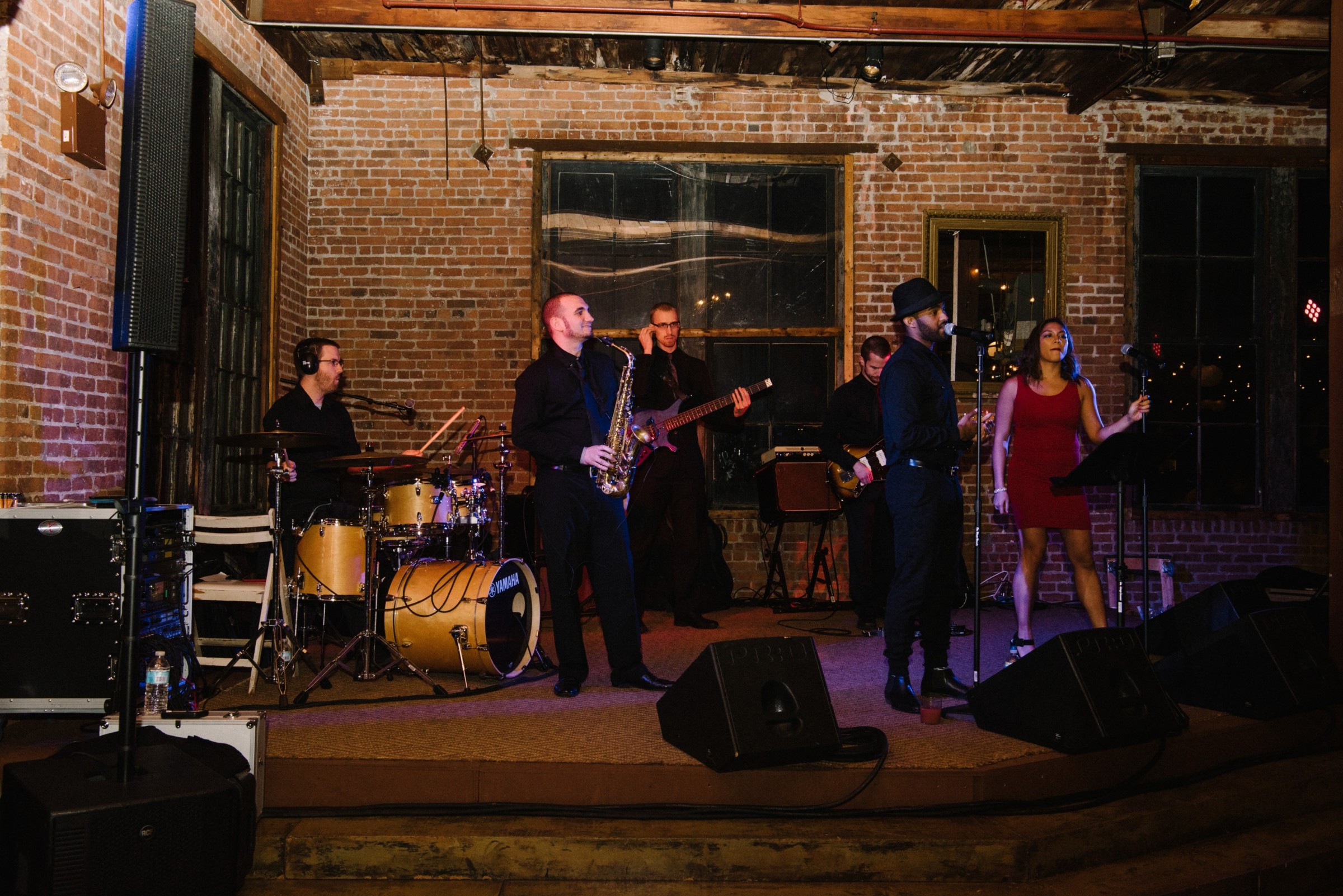 Live band performing on rustic stage with warm lighting and brick walls in New York City.