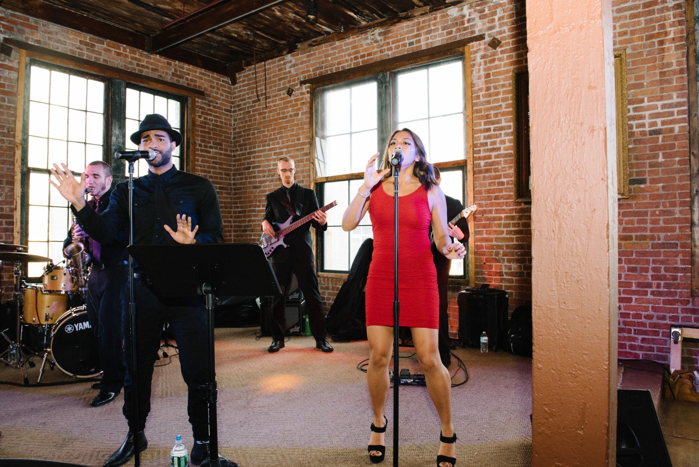 Live band performing in rustic New York venue with exposed brick walls and warm lighting.
