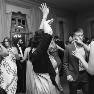 Black and white photo of joyful guests dancing at an elegant Crane Estate wedding in Ipswich.