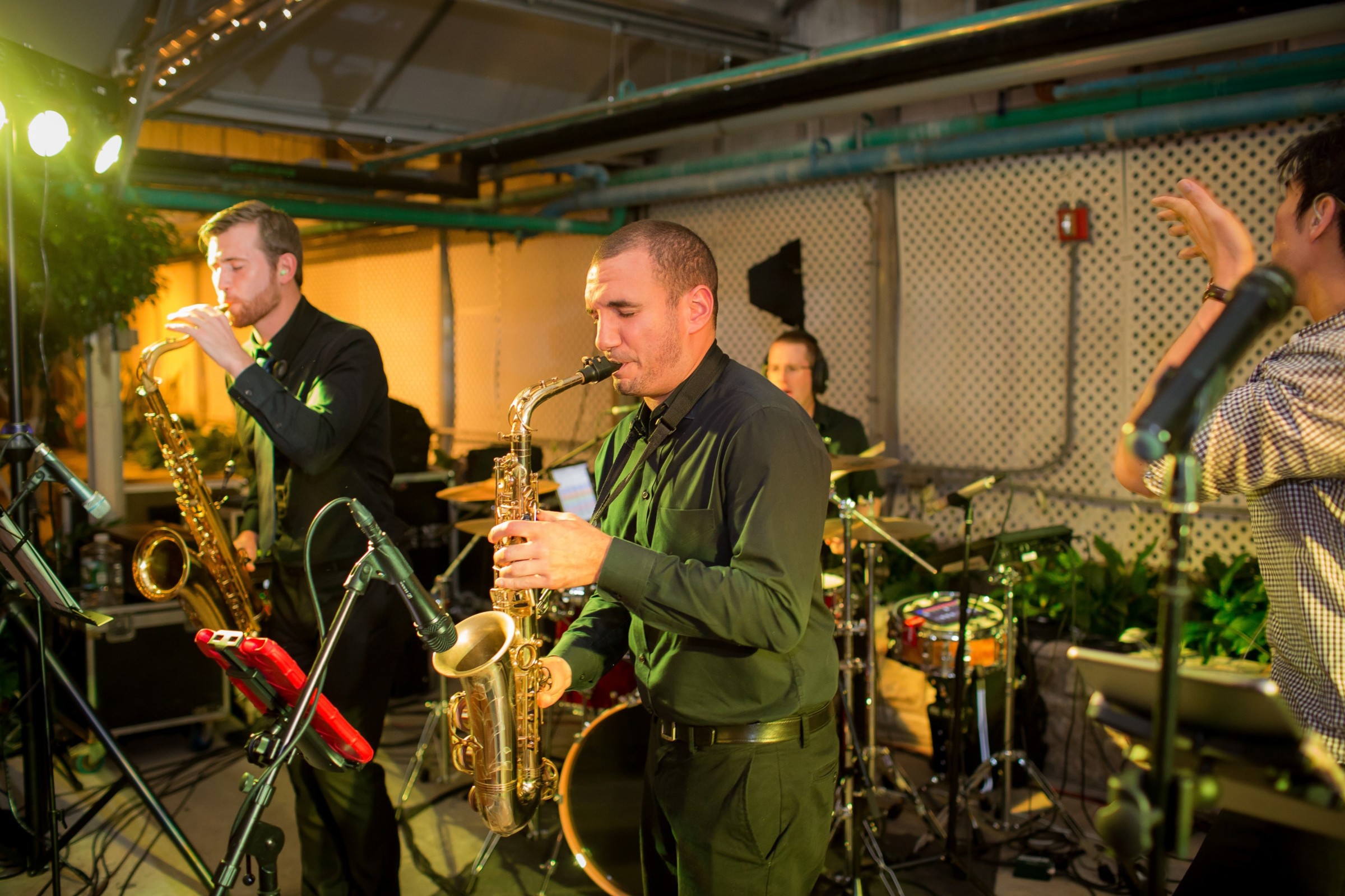 Live jazz band performing with saxophonists, drummer, and vocalist at a Philadelphia indoor venue.