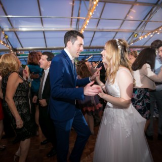 Bride and groom dancing joyfully at Fairmount Park Horticulture Center wedding in Philadelphia.
