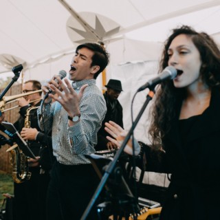 Live band performing under white canopy at outdoor wedding reception in Newbury, Massachusetts.