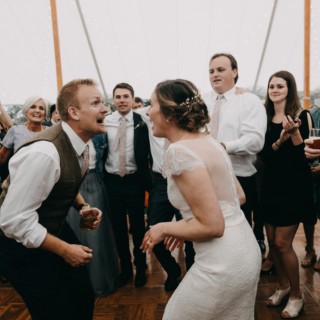 Bride and groom dancing joyfully under string lights at Spencer-Peirce-Little Farm wedding in Newbury.