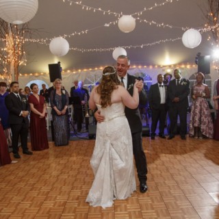 Bride and groom share a romantic first dance under twinkling lights at Waterville Valley wedding.
