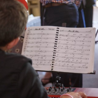 Jazz pianist performing on red Nord keyboard with sheet music at wedding reception in New Hampshire