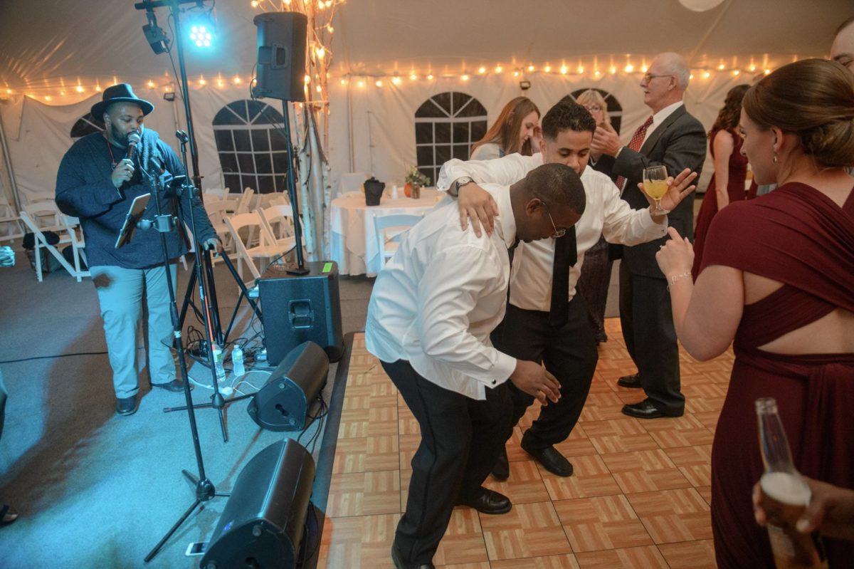 Guests dancing and celebrating under string lights at a joyous Waterville Valley wedding reception.